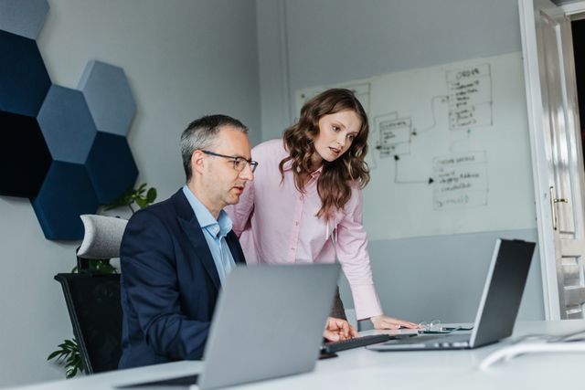 Two Engenious colleagues discussing work at a laptop